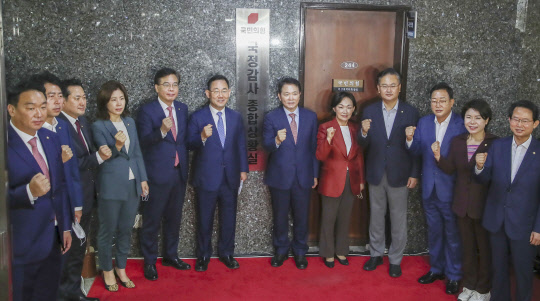 국민의힘 주호영(왼쪽 여섯째) 원내대표를 비롯한 의원들이 27일 서울 여의도 국회 본관에서 열린 국민의힘 국정감사 종합상황실 현판식에서 기념촬영하고 있다.<국회사진기자단·연합뉴스>